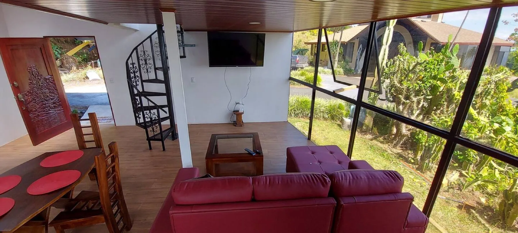 Open-plan living room with spiral staircase and glass wall
